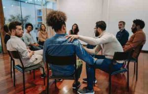 Stock image of people sat in a circle at some form of support group 