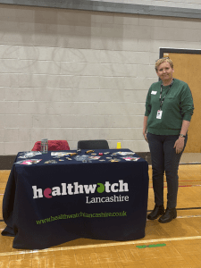 engagement officer louise stood infront of the healthwatch lancashire table setup at preston college freshers fair